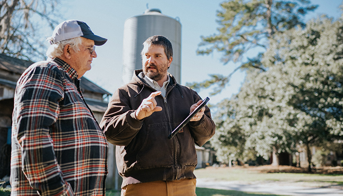 Kendall Kirk discussing information from ipad with farmer