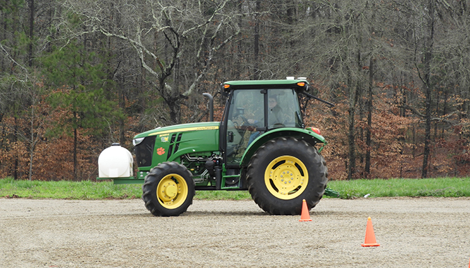 a green tractor on gravel