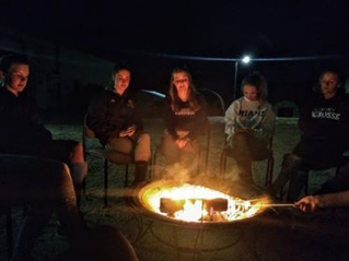 camp participants sitting around a campfire