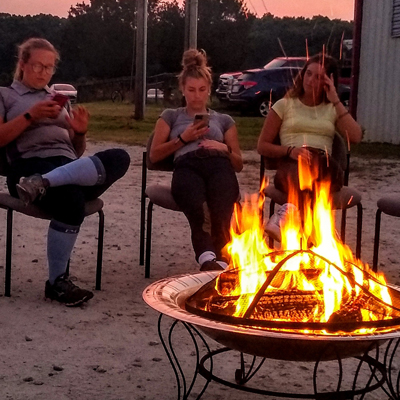 camp participants sitting around a campfire