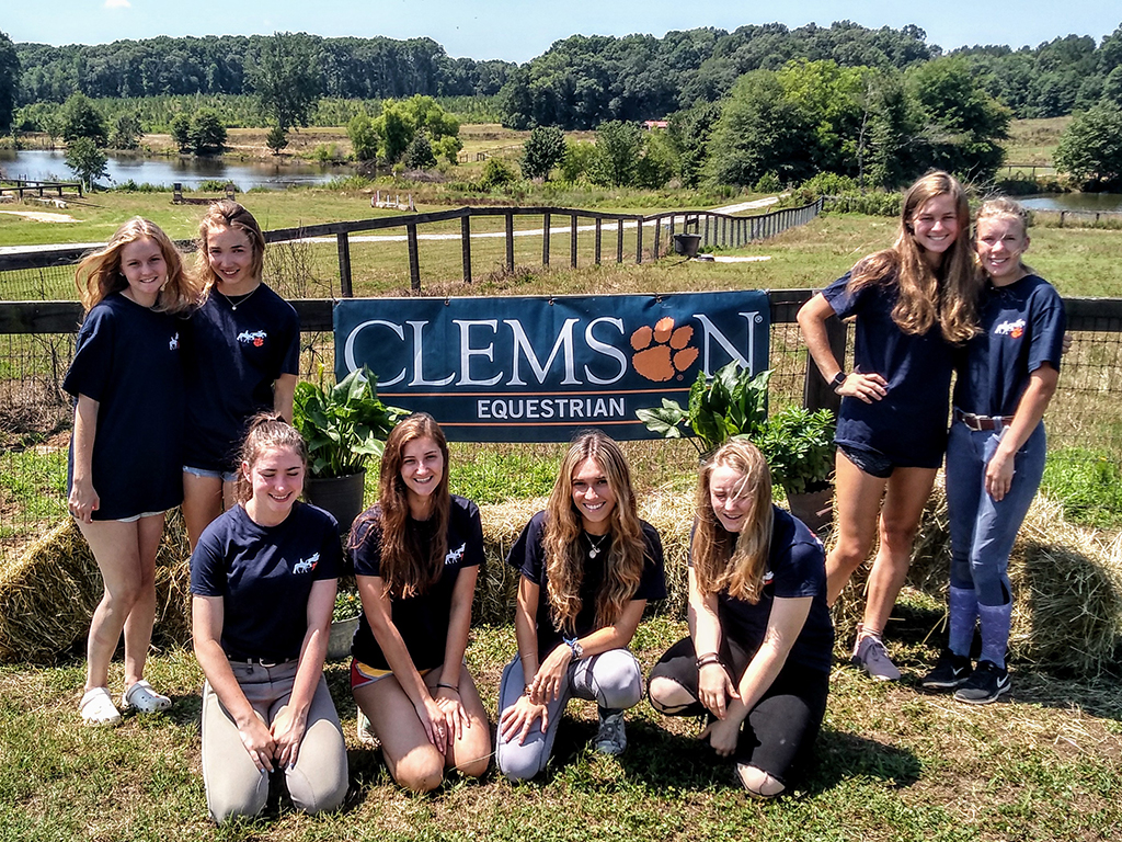 group of smiling girls posing on the Equine Center grounds