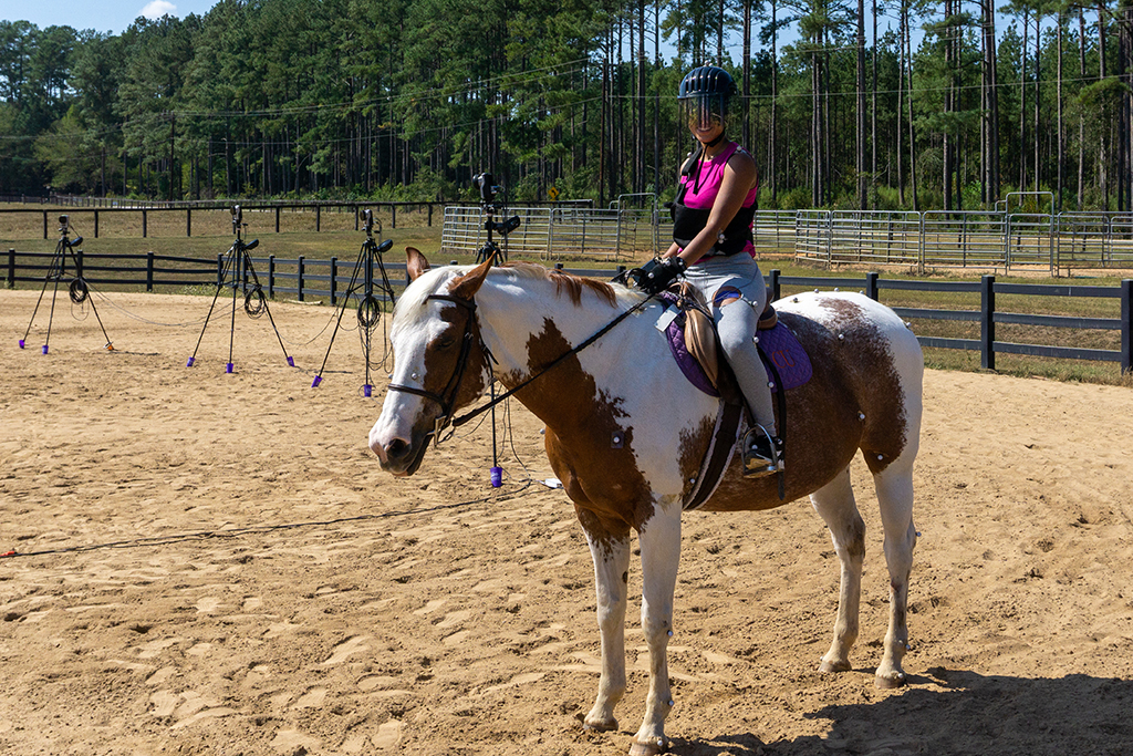 girl smiling while riding a horse