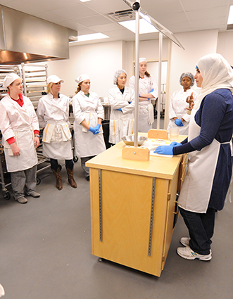 food students listening to lecture in kitchen