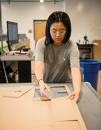 student assembling poinsettia box