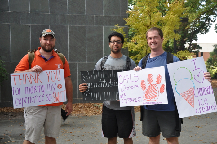 Students with signs thanking donors
