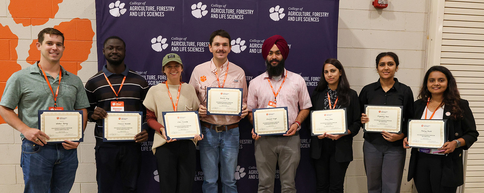 group photo of the 2024 graduate symposium winners holding their awards