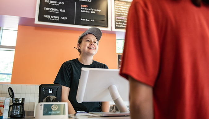 Smiling student worker talking with customer
