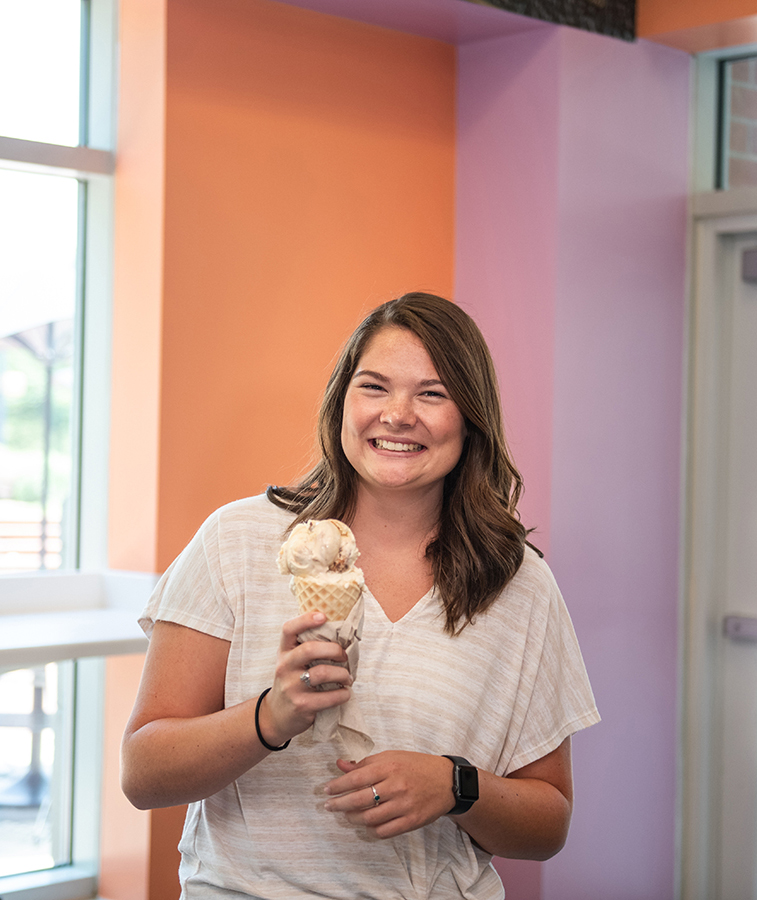 Female smiling while holding an ice cream cone inside 55 Exchange