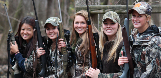 Female students posing with rifles