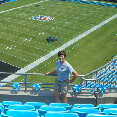clemson student standing in front of carolina panthers football field