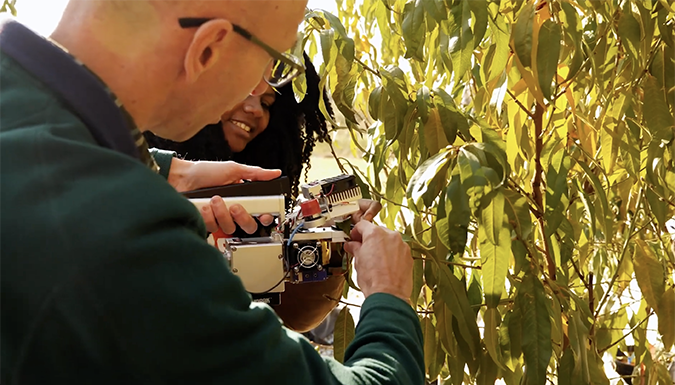 Juan Carlos Melgar and student examining peach crop