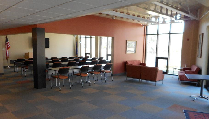 conference room with large table and chairs around, near a wall of windows overlooking treetops