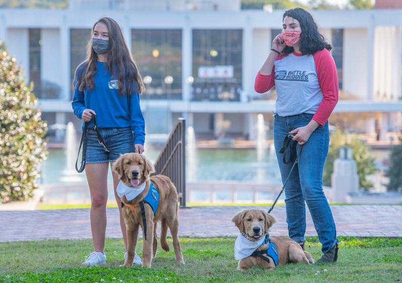 2 students with battle buddy service dogs on leashes