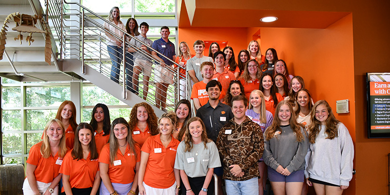 group photo of all of the college's student ambassadors sitting with Dean Belli and Associate Dean Bertrand