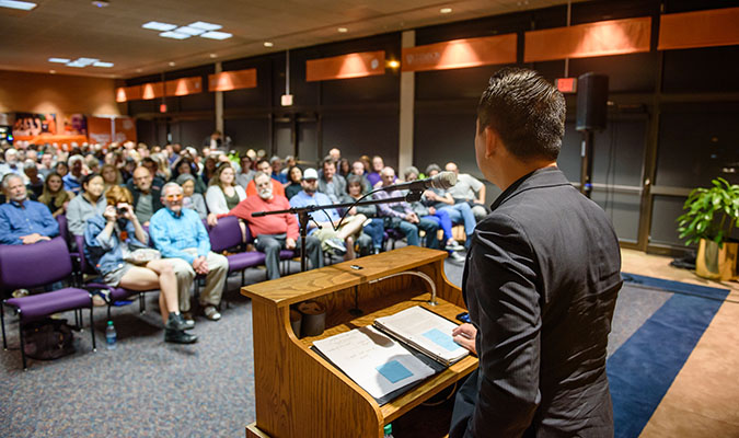 Speaker at lectern with audience