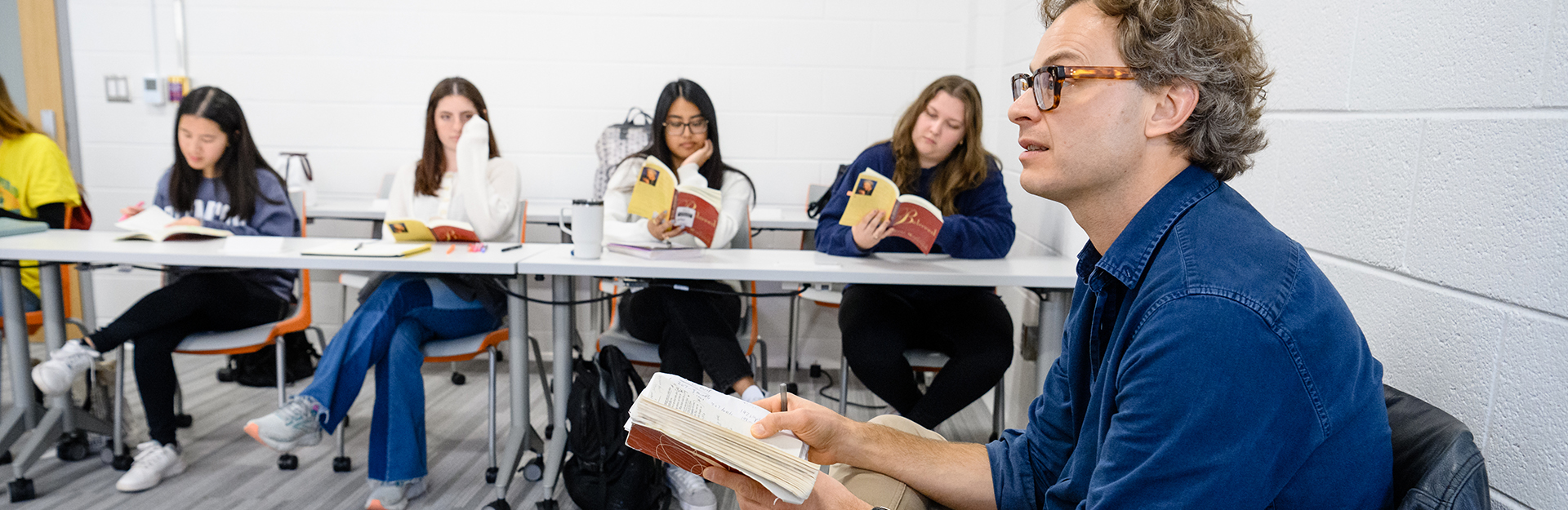 A group of students sit at a table and talk