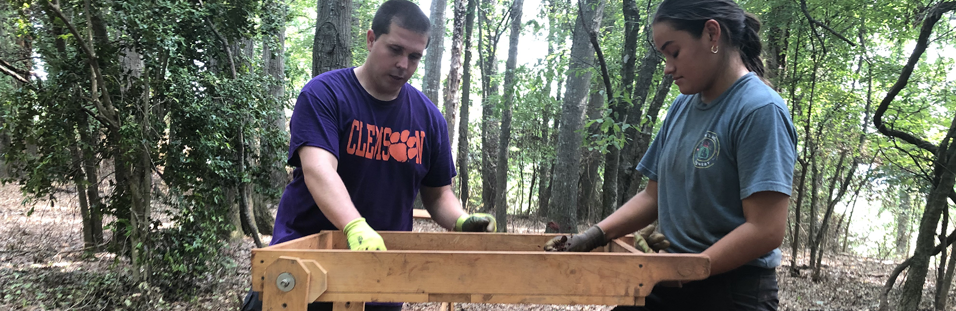 student sifting archaeology material