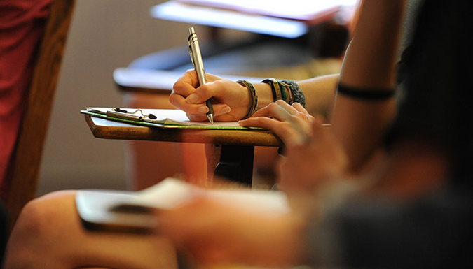 student writing at desk