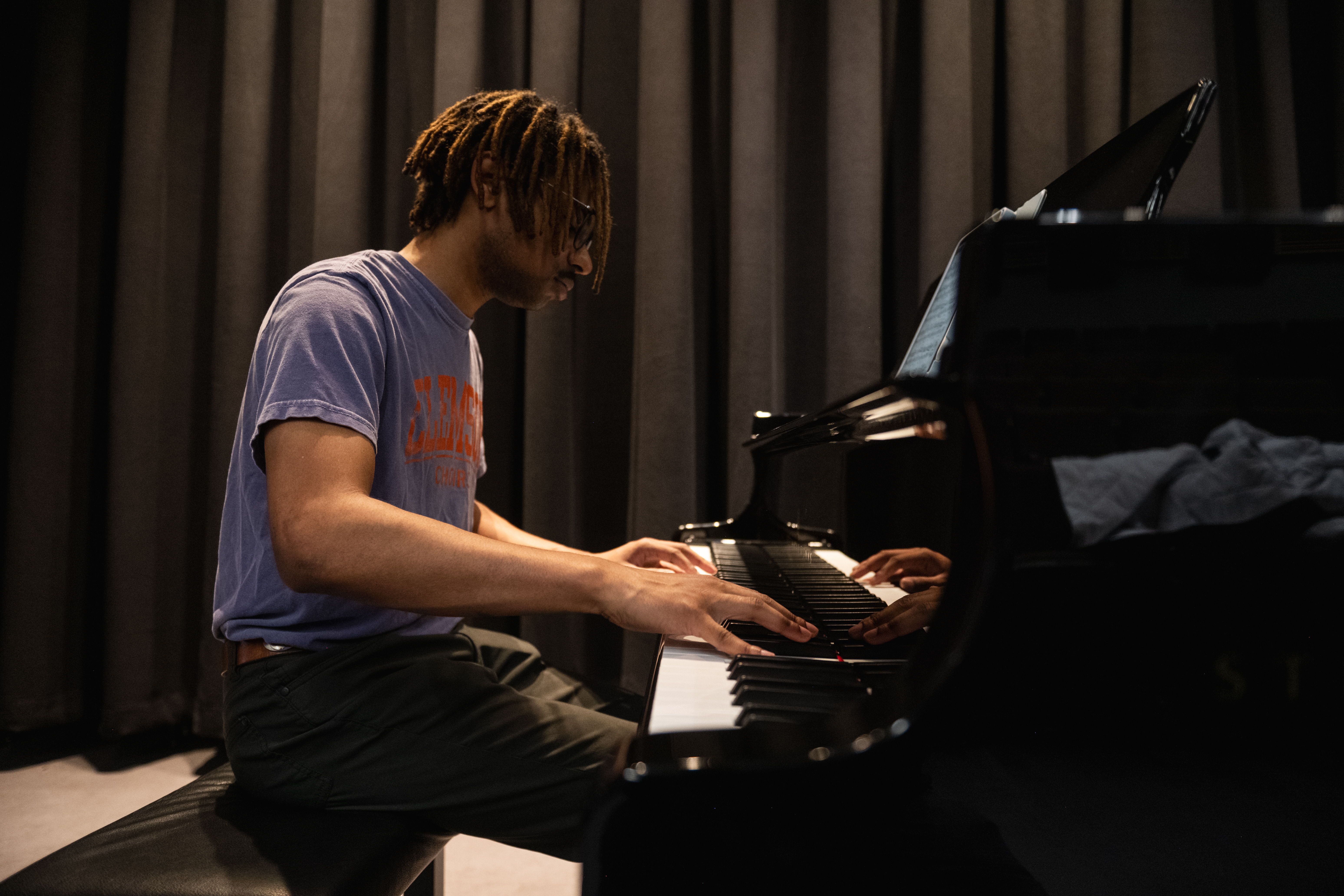 A student plays on a Steinway piano in a recital hall