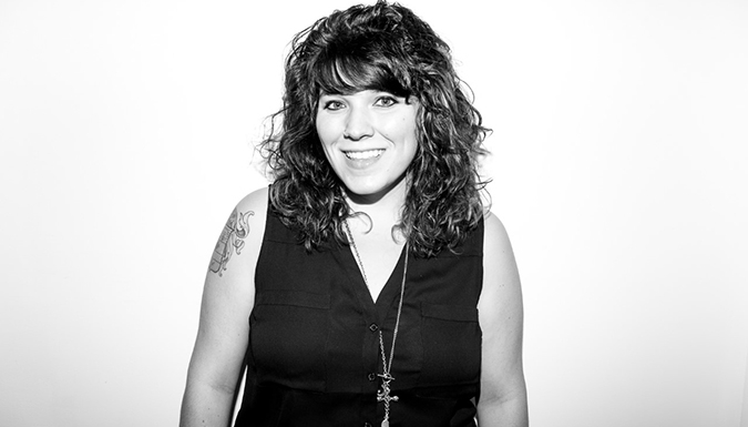 Erin Parisi smiles in black and white image