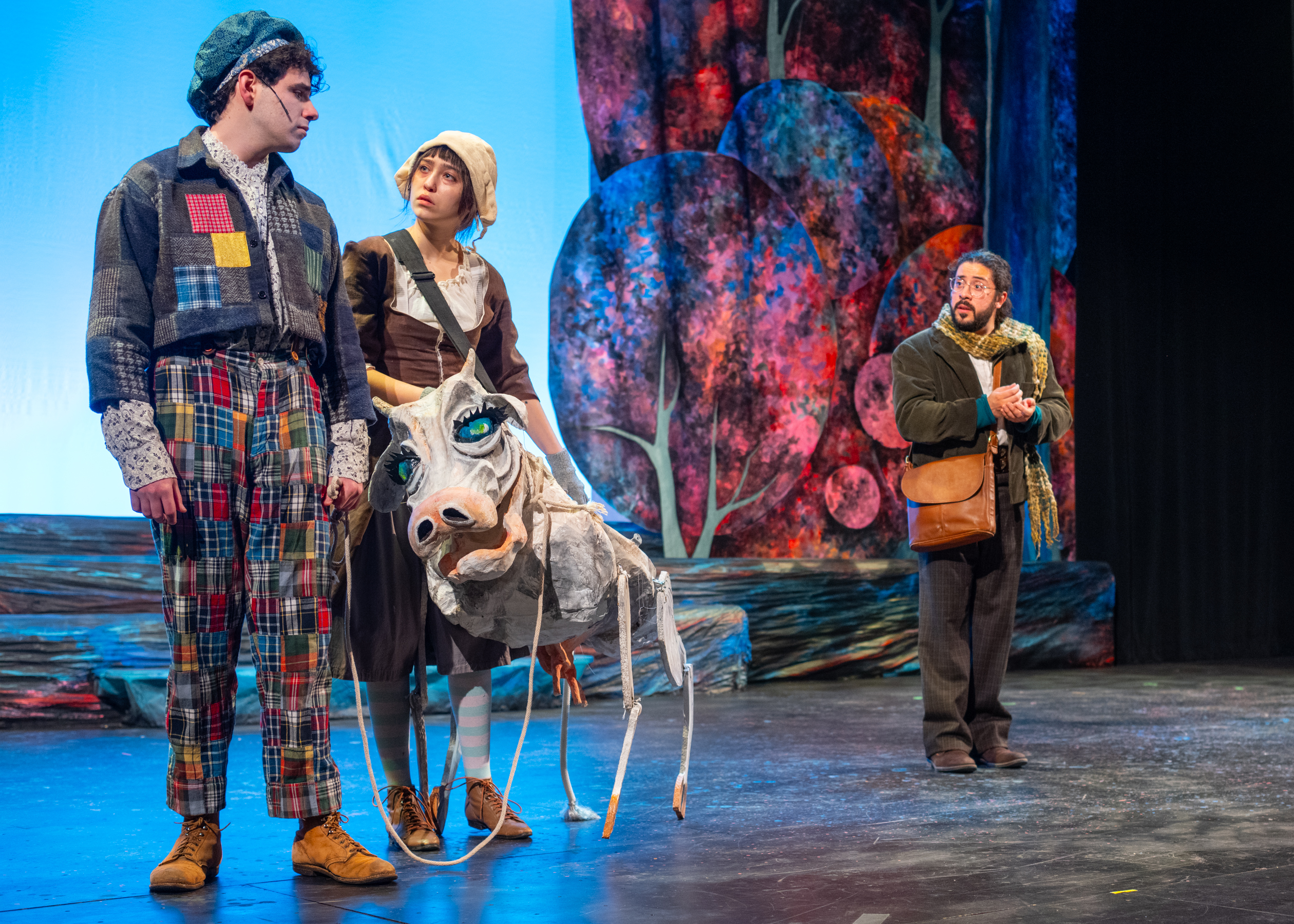 Production photo from the Clemson Players production of Into the Woods. Actors pose on stage with with a puppet cow.