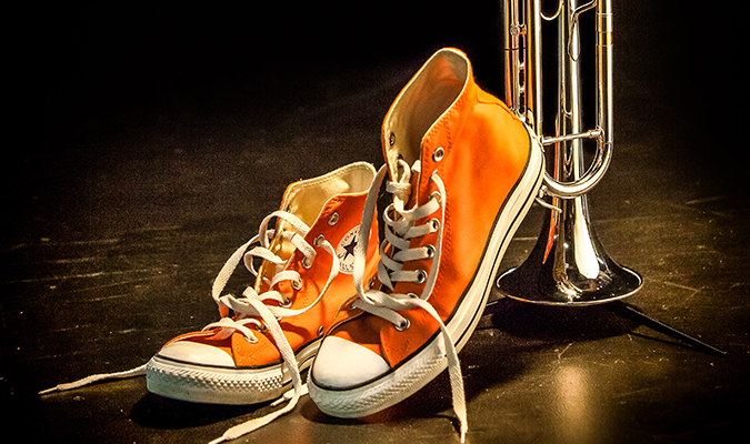 Orange converse next to silver trumpet