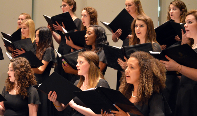 Members of Women's Choir sing on stage