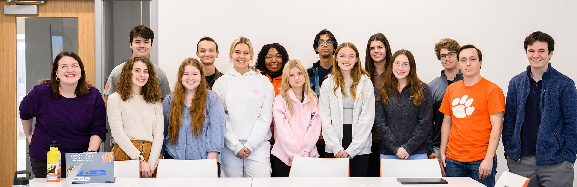 A classroom of students and their professor smiling