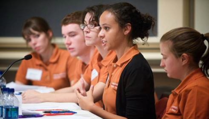 Students speaking at a desk