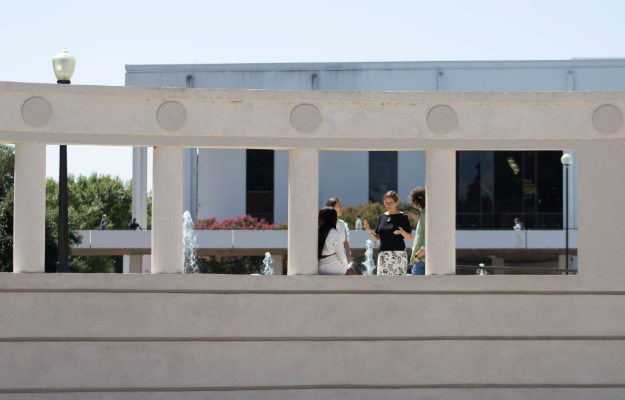 People standing between columns and talking to each other