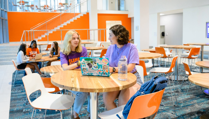 To students smiling and talking at a table
