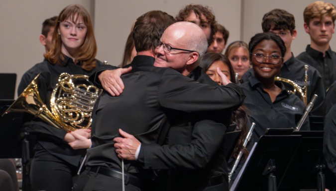 Two people hug at a concert