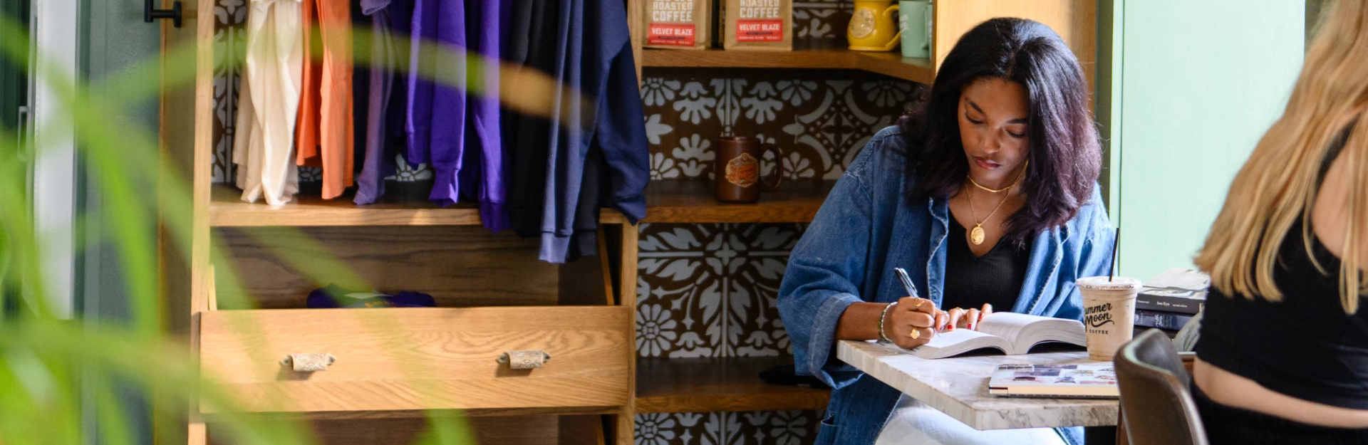 A woman sitting in a coffee shop, writing