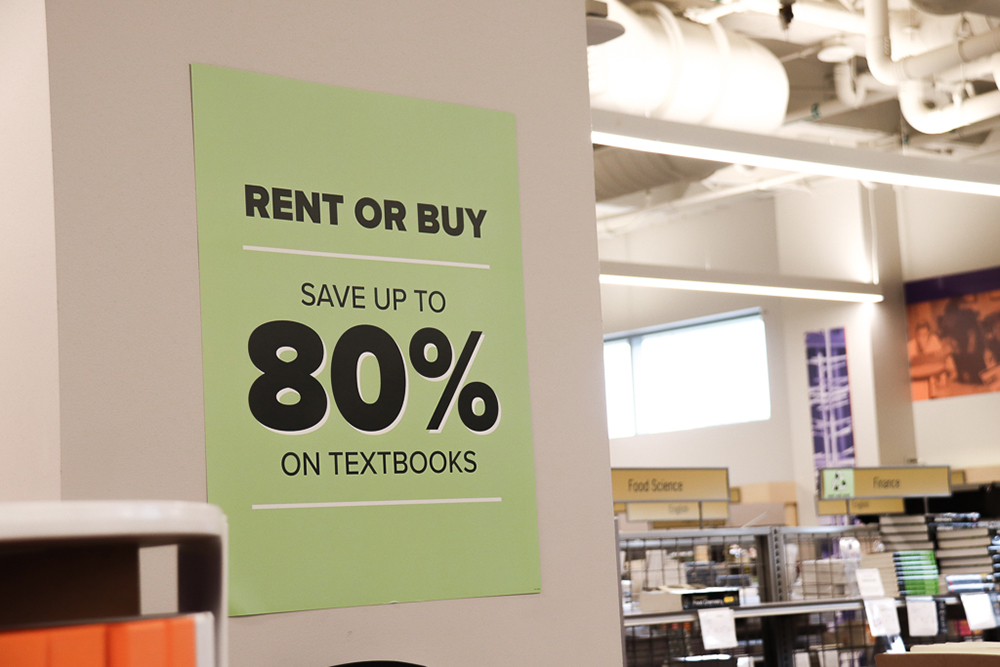 Sign stating Rent or Buy Save up to 80% on Textbooks featured next to the textbooks section in the bookstore