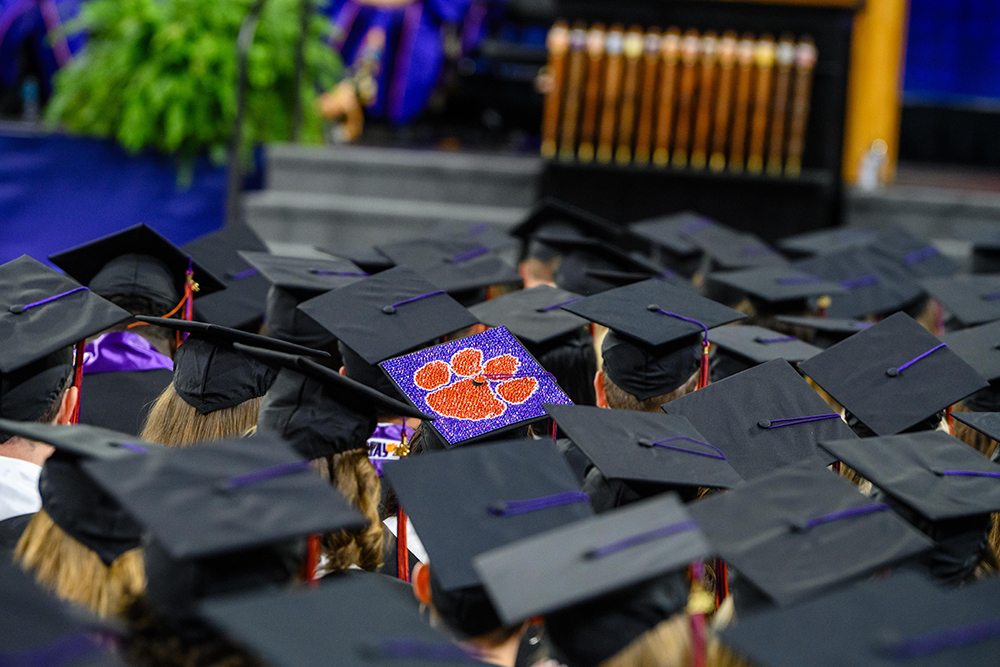 Graduation caps at graduation with a Clemson Tiger Paw on the top of one cap