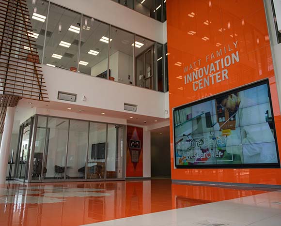 View of the Watt Center main lobby with a large screen on the right and two empty classrooms right in front of the camera.