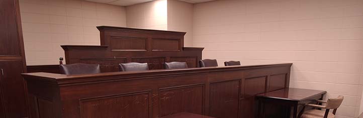An empty court room with the judge's table at the front of the room.