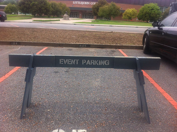 Barricade with Event Parking in white text sitting in an open parking space. 