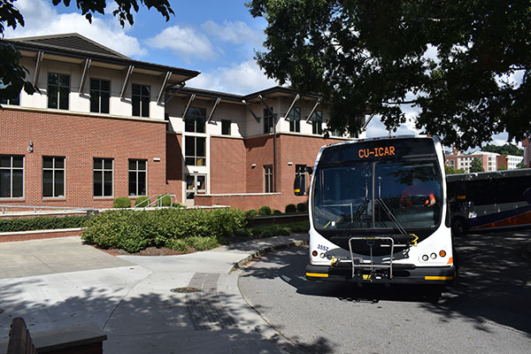 Tiger Transit bus with CU-ICAR  marquee across the top leaving Bracket Hall.