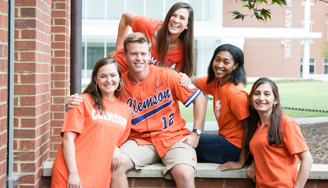Five people in Clemson regalia posing for a photo.