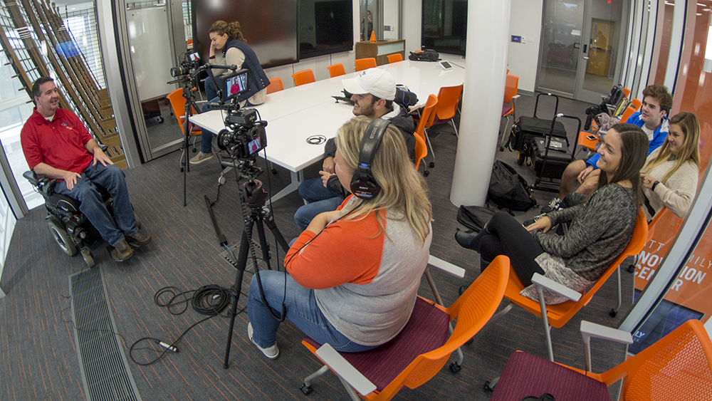 Image of students conducting an interview with a subject in a wheel chair