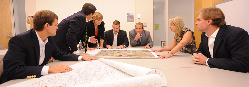People gathered around a desk looking at a map
