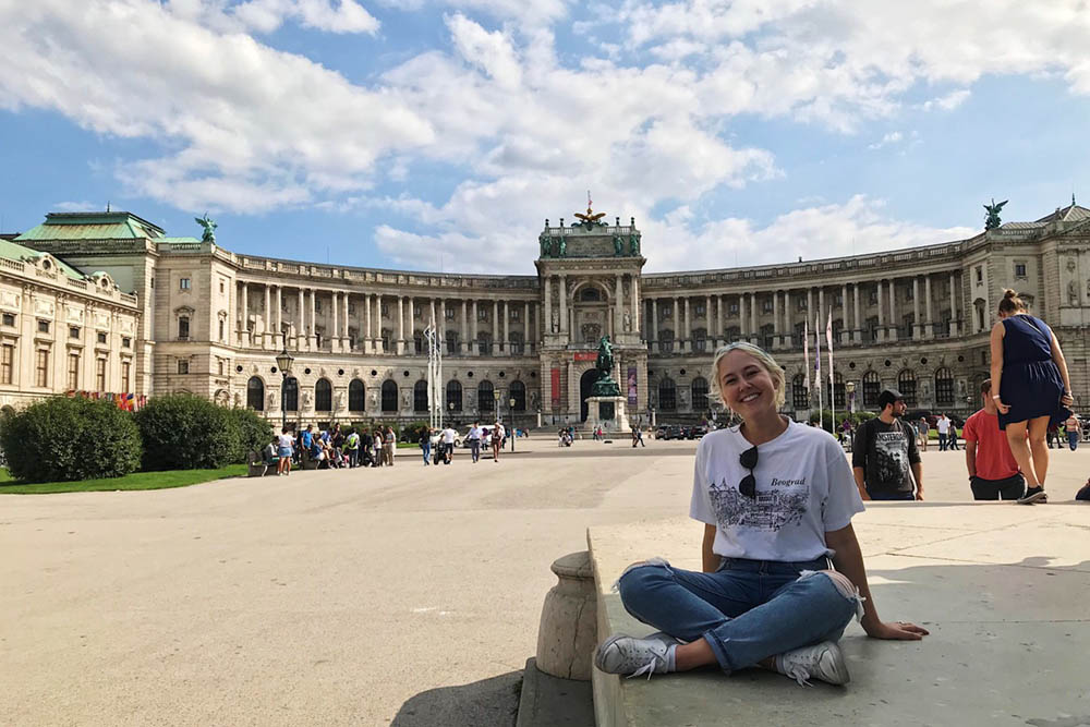 Image of student in front of a building