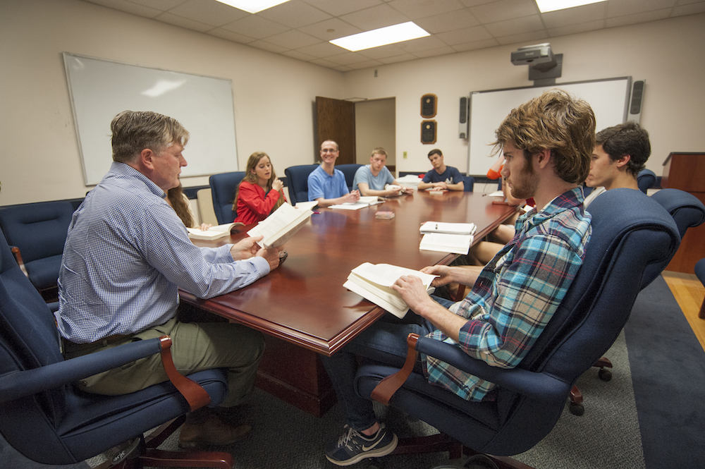 Image of a teacher and students sitting around a desk