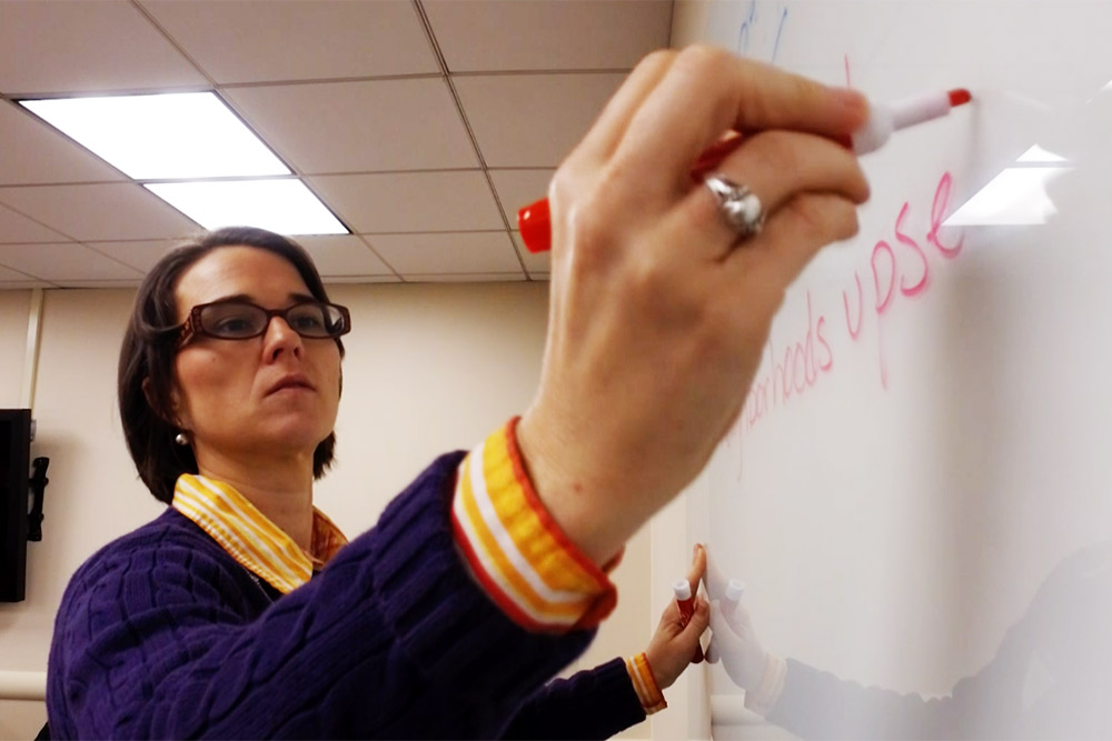 Image of woman writing on a white board