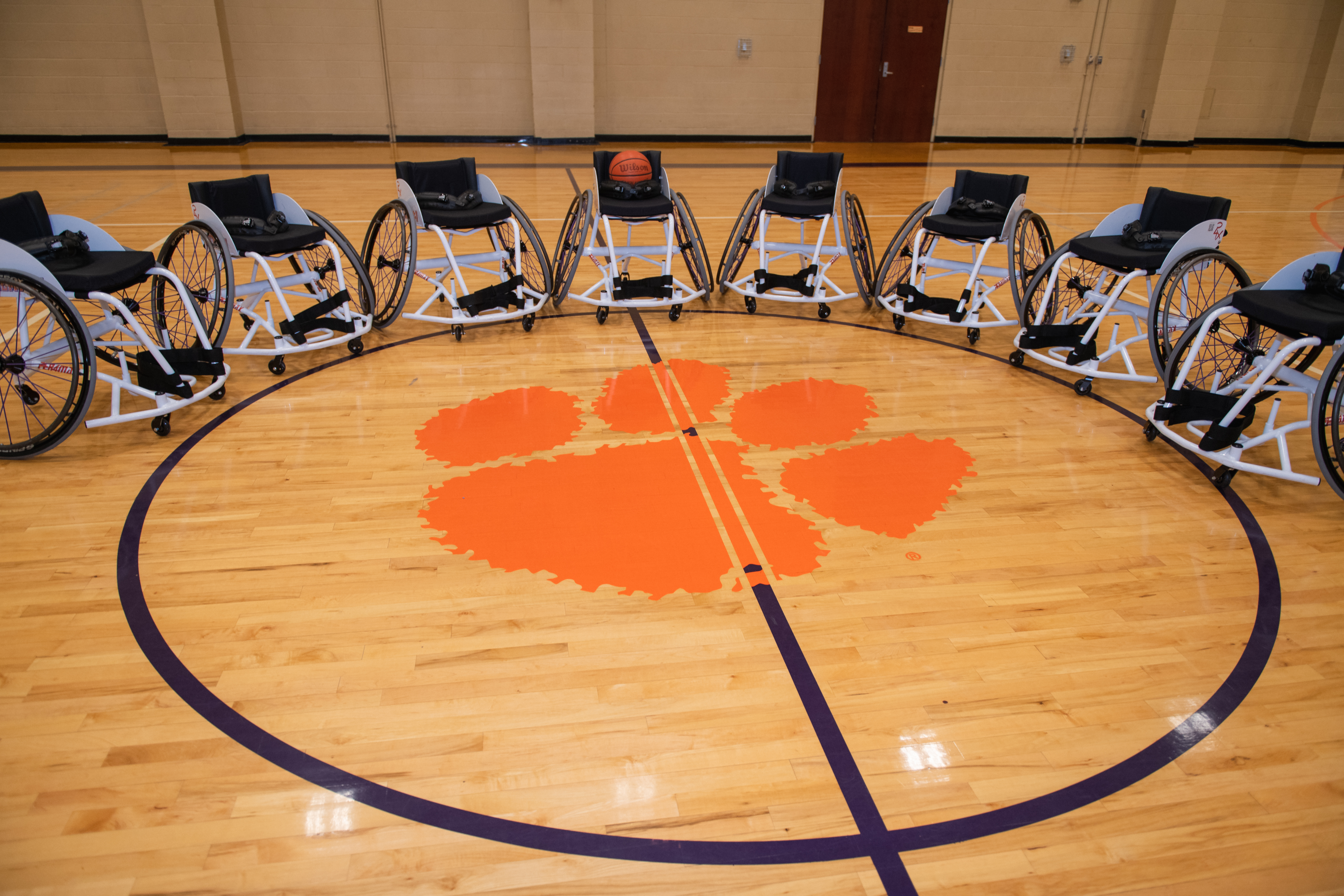 Athletic wheelchairs lined up around the Clemson Tiger Paw.