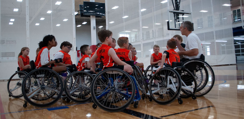 Middle School kids in wheelchairs playing adaptive basketball