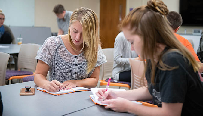 Picture of former EDGE students working at a classroom table.