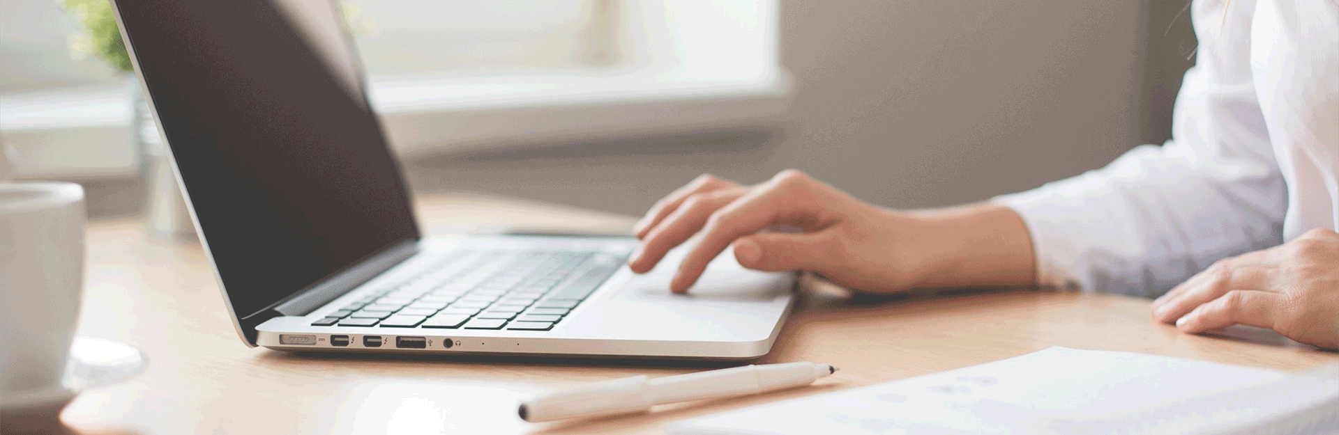 A close up of a laptop with someone using the touchpad to navigate.