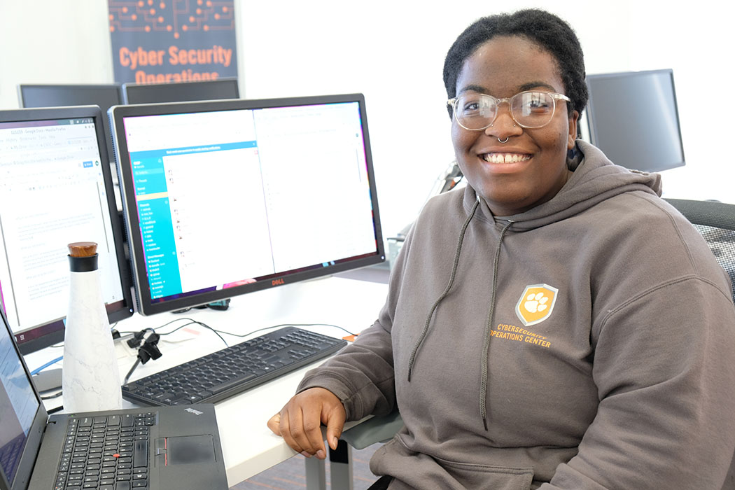 A Security Operations Center intern sitting at an desk with a computer.